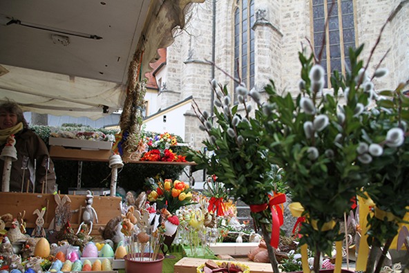 Ein Stand am Altöttinger Fastenmarkt mit Palmbuschen im Vordergrund.