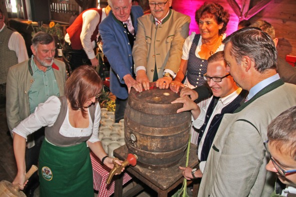 Auf der Altöttinger Kirta zapft Christine Burghart ein Bier Faß an.