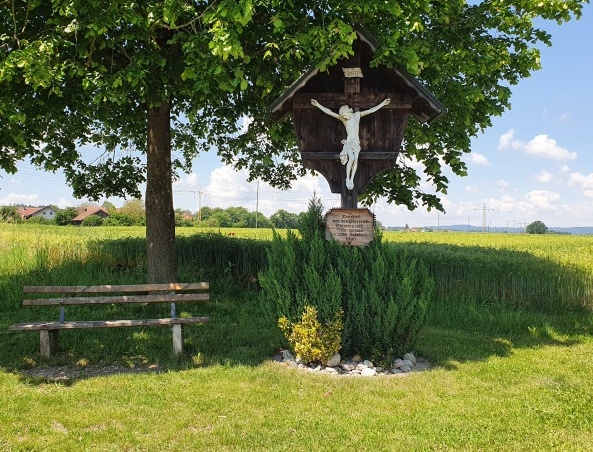 Hier sehen SIe eine Bank mit einem Kreuz am Lande bei Heiming