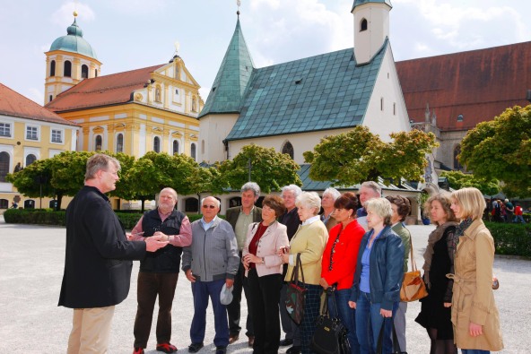 Eine Stadtführung in Altötting, bei der auf dem Kapellplatz verschiedene Dinge erklärt werden.