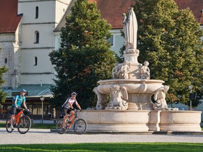 Hier shen Sie zwei Fahrradfahrer am Kapellplatz vor dem Marienbrunnen
