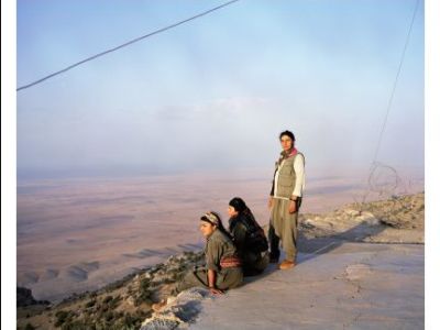 Ausstellung "Auf der Flucht" in Altötting, Foto Sonja Hamad Drei Frauen in der Wüste auf einem Berg, zwei sitzen am Boden.