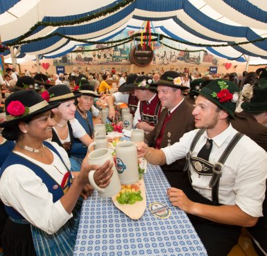 Hofdult Altötting Bierzelt, Foto Heiner Heine Menschen in Tracht sitzen im Bierzelt und trinken Bier.
