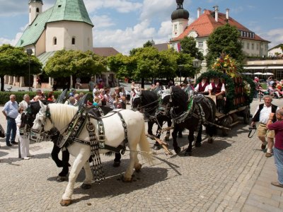 Eine Pferdekutsche zieht einen Wagen mit Bierfässern am Kapellplatz.