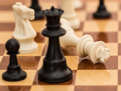 Schachfiguren auf einem Schachbrett, der König ist geschlagen.