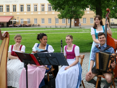 Fünf junge Musiker in Tracht am Kapellplatz. 
